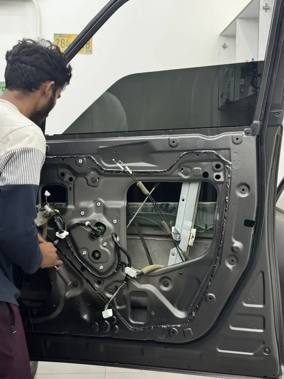 Zenfo technician working on vehicle wiring inside a door panel